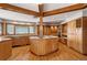 Traditional kitchen with wood beams, custom cabinetry, an island cooktop, and hardwood floors, offering timeless appeal at 1961 S Xenia Ct, Denver, CO 80231