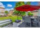 Outdoor dining area on the patio with a red umbrella, a heat lamp, and a green lawn at 11716 Fairplay St, Commerce City, CO 80603