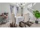 A modern dining room illuminated by a unique chandelier next to the stairway and luxury vinyl plank flooring at 11716 Fairplay St, Commerce City, CO 80603