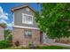 Well-maintained home with brick and siding exterior, accented by a mature shade tree and fountain at 11716 Fairplay St, Commerce City, CO 80603