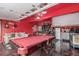 This converted garage features a bar, pool table, and entertainment area with fun, red walls at 11716 Fairplay St, Commerce City, CO 80603