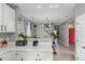 An open-concept kitchen flows into the home's living spaces with luxury vinyl plank floors and a bright red door at 11716 Fairplay St, Commerce City, CO 80603