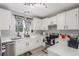 This kitchen features white cabinets, modern fixtures, and luxury vinyl plank floors at 11716 Fairplay St, Commerce City, CO 80603