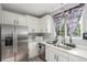 The kitchen area is equipped with stainless steel appliances, white cabinets, and modern sink fixtures at 11716 Fairplay St, Commerce City, CO 80603