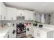 The kitchen showcases white cabinets, stainless steel appliances, quartz countertops, and luxury vinyl plank flooring at 11716 Fairplay St, Commerce City, CO 80603