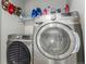 Modern laundry room featuring front-loading Samsung washer and dryer with overhead storage shelf at 11716 Fairplay St, Commerce City, CO 80603