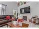 This living room features a fireplace, tall ceilings, and a comfy brown leather sofa and a wooden coffee table at 11716 Fairplay St, Commerce City, CO 80603