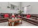 A cozy living room features a large brown leather sofa and wooden coffee table on a plush rug at 11716 Fairplay St, Commerce City, CO 80603