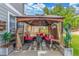Enjoy this covered outdoor patio featuring comfortable seating and a cozy fire pit, surrounded by lush greenery at 11716 Fairplay St, Commerce City, CO 80603
