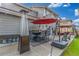 Outdoor patio showcases a dining table with an umbrella, fire pit and heaters for year-round enjoyment at 11716 Fairplay St, Commerce City, CO 80603