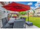 Charming patio features a fire pit table, red umbrella, outdoor furniture and a lush green lawn at 11716 Fairplay St, Commerce City, CO 80603