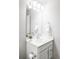 Well-lit bathroom featuring a white vanity, framed mirror, decorative plant, and towel rack at 5099 S Robb St, Littleton, CO 80127