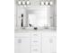Bright bathroom with dual sinks, sleek white cabinets, and modern lighting provides a clean and functional space at 5099 S Robb St, Littleton, CO 80127