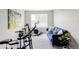 Inviting bedroom is staged as a home gym, featuring a comfortable couch, exercise bike and neutral color palette at 5099 S Robb St, Littleton, CO 80127