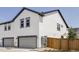 Modern home's exterior with a gray garage door, fresh landscaping, and a wooden fence at 5099 S Robb St, Littleton, CO 80127