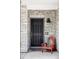 Inviting front entry with a dark-colored door framed by stone and a cute chair offering a warm welcome at 5099 S Robb St, Littleton, CO 80127