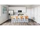 Modern kitchen with white cabinets, stainless steel appliances, quartz countertops, and seating area, offering style and function at 5099 S Robb St, Littleton, CO 80127