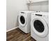 Modern laundry room with new, front-loading washer and dryer, and a functional shelf at 5099 S Robb St, Littleton, CO 80127