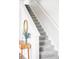 Bright staircase features plush carpeting and a white banister, complemented by a stylish entry table and accent mirror at 5099 S Robb St, Littleton, CO 80127