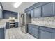 Modern kitchen with blue cabinets, granite counters, and stainless steel appliances at 6250 S Windermere St, Littleton, CO 80120