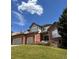 Charming two-story brick home with a landscaped lawn, attached garage, and a welcoming front entrance at 6577 Esperanza Dr, Castle Pines, CO 80108
