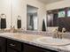 Bathroom featuring double sinks with granite countertop, modern fixtures and vanity at 5358 Ventura St, Denver, CO 80249