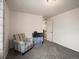 Minimalist bedroom with carpet, a striped chair, and a storage unit with access to a staircase at 5358 Ventura St, Denver, CO 80249