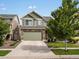 Two-story home featuring stone accents, an attached two-car garage, and professionally landscaped front yard during the daytime at 5358 Ventura St, Denver, CO 80249