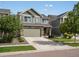 Exterior of a two-story home with stone accents, a two-car garage, and professionally landscaped yard in daylight at 5358 Ventura St, Denver, CO 80249