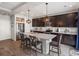 Modern kitchen featuring stainless steel appliances, granite countertops, a large island, and dark wood cabinetry at 5358 Ventura St, Denver, CO 80249