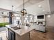 Bright open kitchen with a large island, modern pendant lights, and an adjacent living room at 5358 Ventura St, Denver, CO 80249
