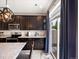 Well-lit kitchen with stainless steel appliances, granite countertops, dark wood cabinets, and a sliding door to the patio at 5358 Ventura St, Denver, CO 80249