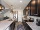 Modern kitchen with stainless steel appliances, granite countertops, a large island, and dark wood cabinetry at 5358 Ventura St, Denver, CO 80249