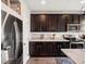 Spacious kitchen with stainless steel refrigerator and appliances, next to dark cabinets and white countertops at 5358 Ventura St, Denver, CO 80249