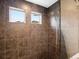 Modern shower with tiled walls, rainfall shower head and natural light from small windows at 5358 Ventura St, Denver, CO 80249