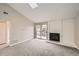 Bright living room featuring a cozy fireplace, modern carpet, and a sliding glass door to the balcony at 4899 S Dudley St # 17G, Littleton, CO 80123