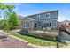 A large backyard features a grass lawn, stone patio, and wooden deck for outdoor living and entertaining at 20529 E Brunswick Pl, Aurora, CO 80013