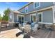 A wooden deck features a dining table set, grill, and sliding glass doors that open to the home's interior at 20529 E Brunswick Pl, Aurora, CO 80013