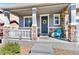 Inviting front porch with stone pillars, a cozy seating area, and a decorative wreath on the door at 20529 E Brunswick Pl, Aurora, CO 80013