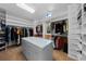 Large walk-in closet featuring custom shelving and a large center island for storage at 2230 E Grand Ave, Cherry Hills Village, CO 80113