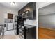 Galley kitchen featuring dark cabinets, stainless steel appliances, and an adjacent living space at 2640 S Marion St # 2646, Denver, CO 80210