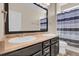 This bathroom offers double sink vanity, large mirror, shower with tub, and a blue and gray striped shower curtain at 3266 Riverwood Way, Castle Rock, CO 80109