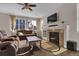 Cozy living room featuring a stone fireplace, large windows for natural light, and comfortable leather furniture at 3266 Riverwood Way, Castle Rock, CO 80109