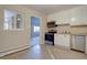 Functional kitchen with white cabinetry, stainless steel appliances, and a view into an adjacent room at 731 Uvalda St, Aurora, CO 80011