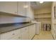 Well-organized laundry room with ample counter space, storage cabinets, and modern appliances at 731 Uvalda St, Aurora, CO 80011