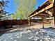 Landscaped backyard with a wooden pergola, rock features, and mature trees at 16351 E 104Th Pl, Commerce City, CO 80022