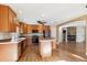 Spacious kitchen with wood cabinets, center island, stainless steel appliances, and adjacent fireplace at 16351 E 104Th Pl, Commerce City, CO 80022
