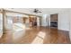 Open-concept living room featuring hardwood floors, stone fireplace, and seamless transition to kitchen at 16351 E 104Th Pl, Commerce City, CO 80022