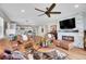 Open-concept living room features a fireplace, leather furniture, and views of the kitchen and dining area at 8829 Animas River St, Littleton, CO 80125