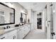 Bright and modern bathroom with double sinks, granite countertops, and a view into the walk-in closet at 8829 Animas River St, Littleton, CO 80125